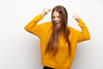 Young woman with yellow over isolated white wall celebrating a victory