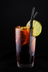 rum with cola and citrus with beautiful backlighting on a black background