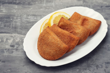 portuguese meat snacks on white dish on ceramic background