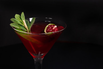 Daiquiri cocktail and beautifully decorated with mint leaves and fresh berries, shot with a large plan on a black background