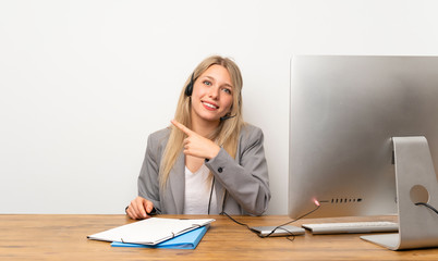 Young woman working with headset pointing finger to the side