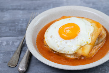 typical portuguese dish francesinha in dish on ceramic background