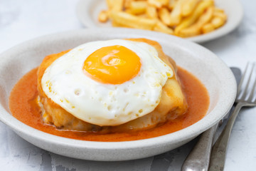 typical portuguese dish francesinha in dish on ceramic background