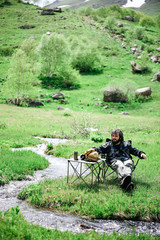 Adventure hiking man with coffee and backpack relaxing after outdoor activity.