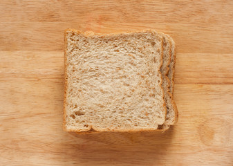 whole wheat breads on a wooden plank