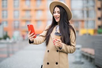 Fototapeta premium Happy young woman walking in the street have video call on smartphone