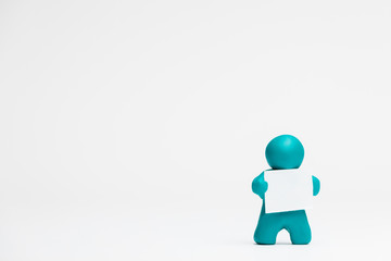 A man made from plasticine holding a blank sheet of paper on white background, aligned to the right.