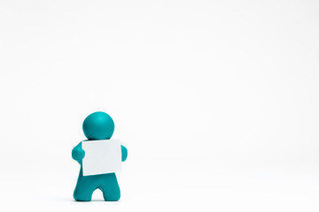 A man made from plasticine holding a blank sheet of paper on white background, aligned to the left.