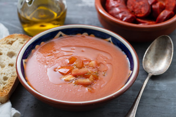 spanish soup gazpacho in bowl with bread and olive oil on ceramic background