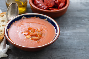 spanish soup gazpacho in bowl with bread and olive oil on ceramic background