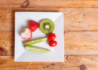Fruit and vegetable salad in a bowl on wooden background,diet weight loss concept.