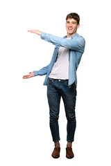 A full-length shot of a Handsome young man holding copyspace to insert an ad over isolated white background