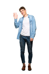 A full-length shot of a Handsome young man saluting with hand with happy expression over isolated...