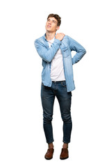 A full-length shot of a Handsome young man suffering from pain in shoulder for having made an effort over isolated white background