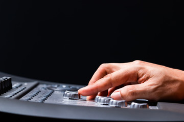 sound engineer fingers adjusting audio level signal on mixing console fader. music production...