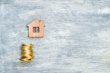 The house symbol is made of bamboo and yellow shiny coins on a scratched concrete background.