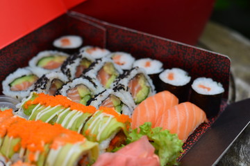 sushi being picked up in front of a box of sushi