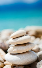 Fototapeta na wymiar Feng Shui elements. Concept harmony. White stones and turquise sea in moments of relaxation. Beautiful beach with sand and stone. Zen stones sand. Mikros Gialos beach, Lefkada, Greece.