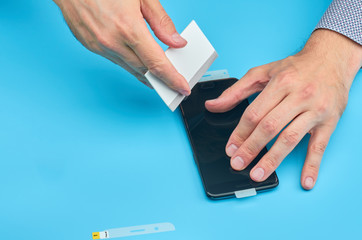 The man replacing the broken tempered glass screen protector for smartphone.