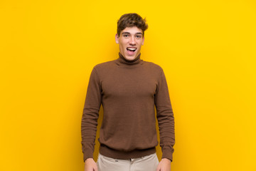 Fototapeta premium Handsome young man over isolated yellow background with surprise facial expression