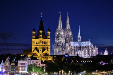 Fototapeta premium Kölner Dom, Groß St Martin Kirche mit Blick die alten Gebäude am Kölner Fishmarkt bei Nacht. Blaue Stunde.