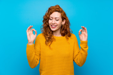 Redhead woman with yellow sweater in zen pose - obrazy, fototapety, plakaty