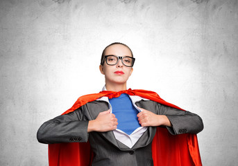 Attractive young business lady in red hero cape