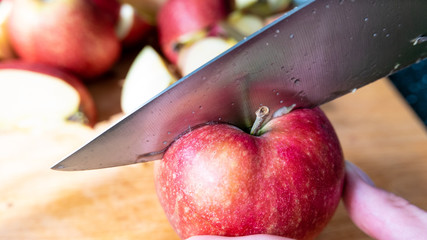 Cutting the red apple with kitchen knife