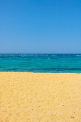 Fototapeta na wymiar sand beach sea and blue sky as an straight beautiful line formation