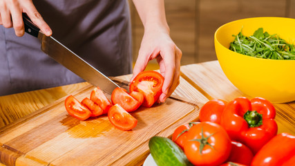 Vegetarian lifestyle. Cropped shot of woman cooking, chopping tomatoes for salad.