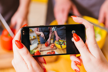 Healthy nutrition video tutorial. Closeup of female hands holding smartphone to film women...