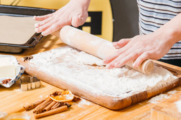 Bakery food and pastry cooking. Closeup of woman hands rolling dough in flour, making gingerbread biscuits.