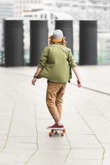 back view of man riding on skateboard at rooftop