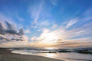 Sunset over the sea. Reflection of sunlight in the sea waves. The sky in the sunset rays.