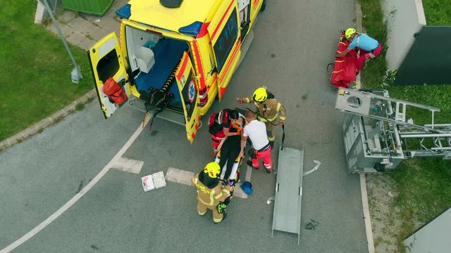A person got injured and a team of rescue workers is trying to get her to the hospital as soon as possible.