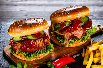Tasty burgers with chips served black stone plate