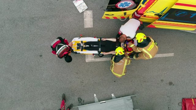 Getting this injured person into the hospital as soon as possible. Aerial shot. A team of rescue workers is working as fast as possible.