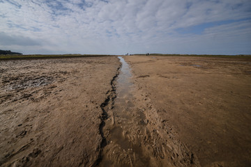 Stream running and flowing through beach to the sea