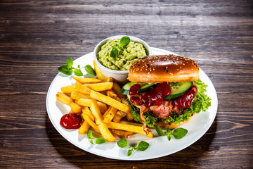 Tasty burger with chips served white plate