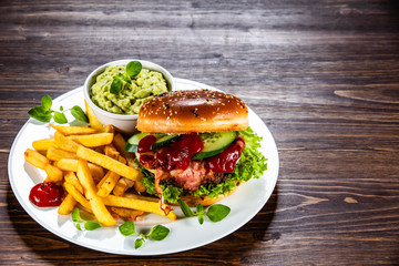 Tasty burger with chips served white plate