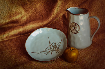 Clay jug and plate. Blue glazing dishes. Handicraft. Pottery skill. Semi-matt background. Selective...
