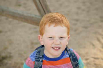 5 years old redheaded happy boy portrait. He is looking at camera