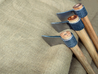 Three tomahawks, also known as hawks, displayed on burlap with bokeh effect. Made from rasps. These...