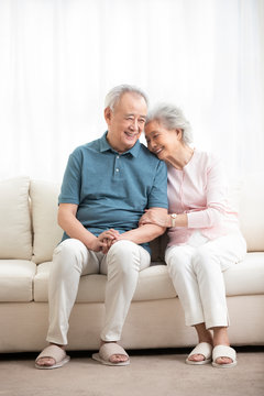 Happy senior couple sitting on sofa