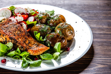 Grilled salmon, baked potatoes and vegetable salad