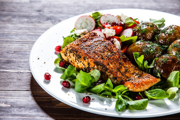 Grilled salmon, baked potatoes and vegetable salad