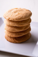 Homemade stack of shortbread cookies on white plate wooden table