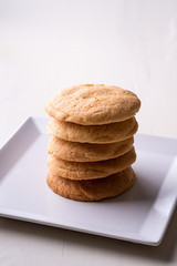 Homemade stack of shortbread cookies on white plate wooden table