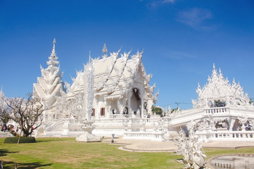 Bridge of 'the cycle of rebirth' and the ornate building of White Temple in a bright day. Chiang Rai province, Thailand