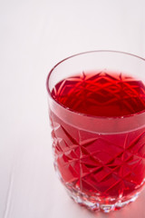 Stewed fruit red compote drink in textured transparent glass